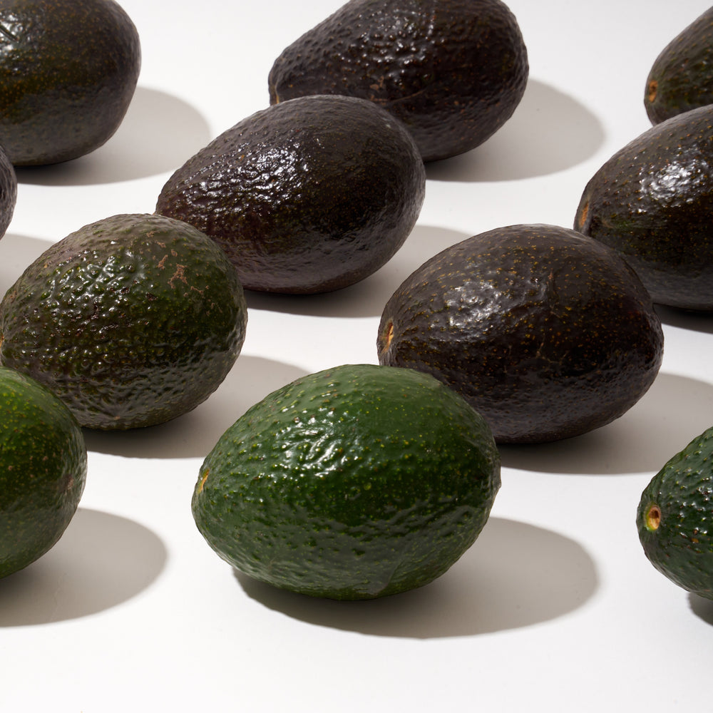 Fresh avocados lined up on a table