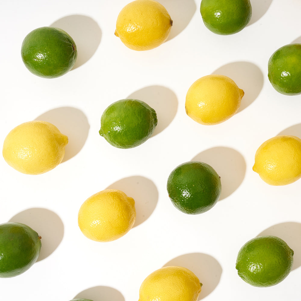Fresh Limes and Lemons lined up on a white background