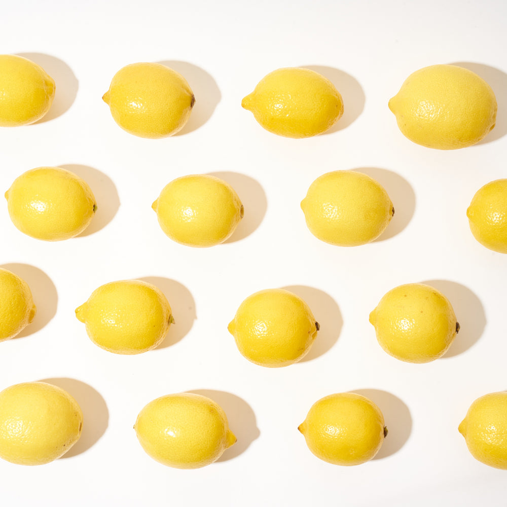 Lined up lemons, yellow lemons on a white background