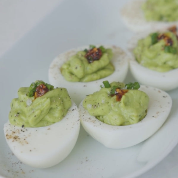 Avocado deviled eggs on white serving plate