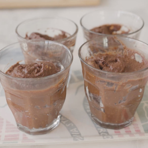 Chocolate Avocado mousse presented in 4 serving glasses on a tray.