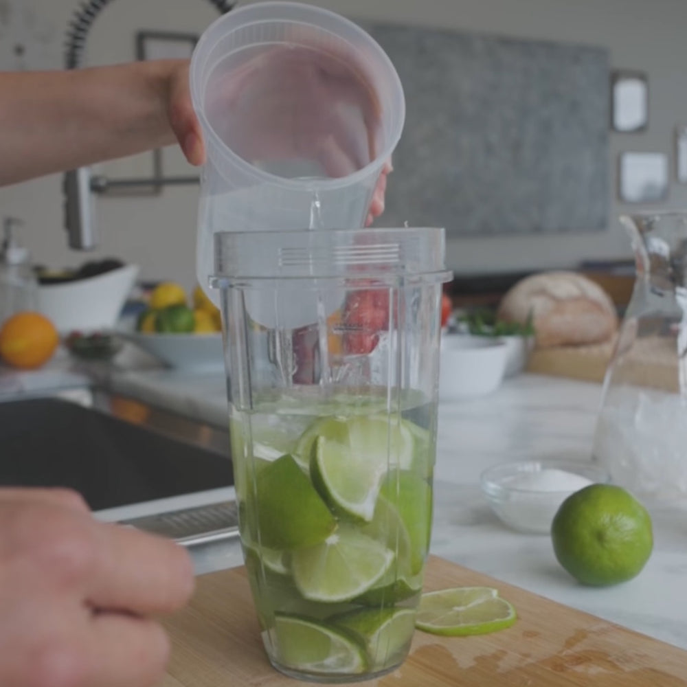 Add limes and half the water to the blender