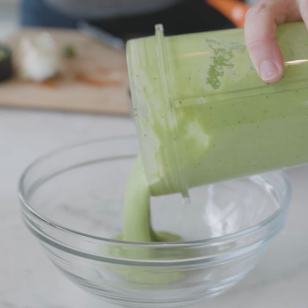 pouring blended avocado mixture into a bowl
