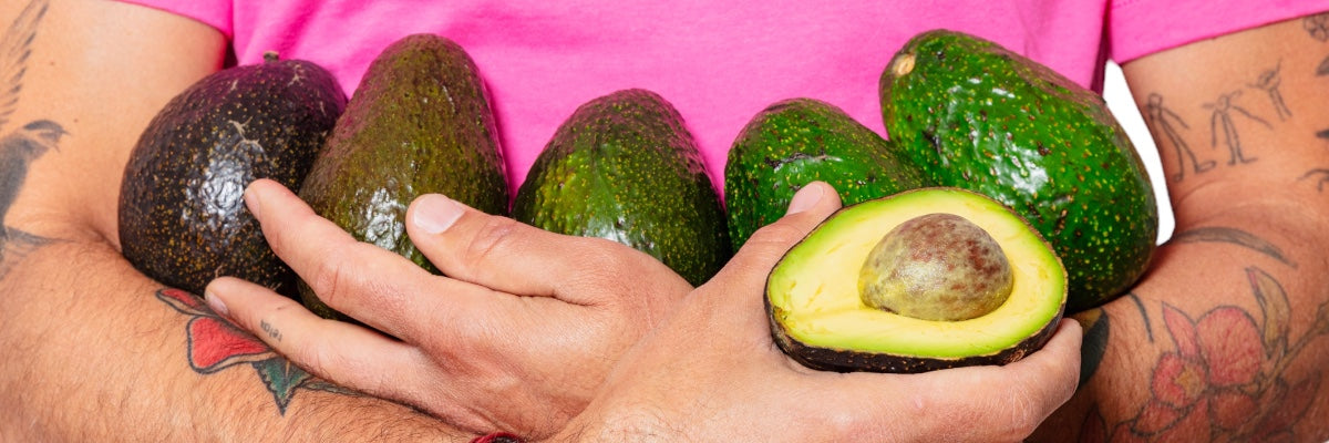 Davocadoguy Avocados from green to ripe cradled in man's arm wearing a Pink T-Shirt.