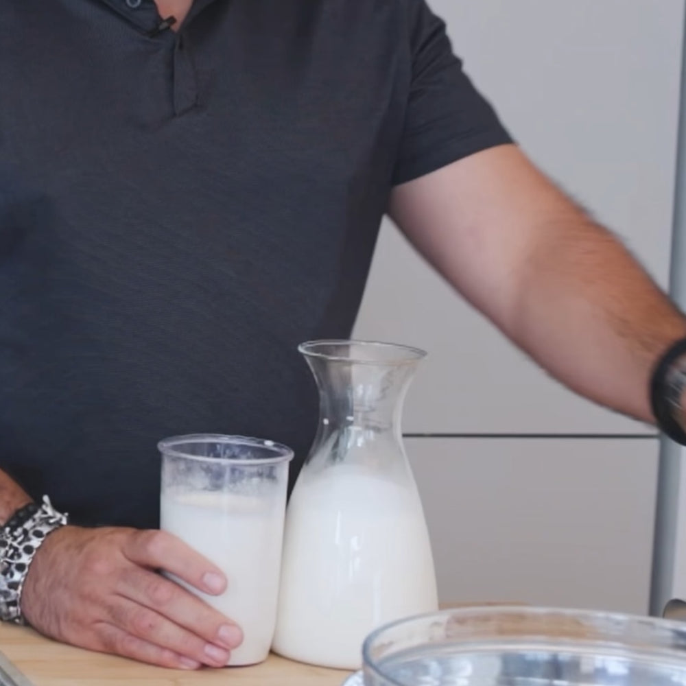 person adding milk in a bowl