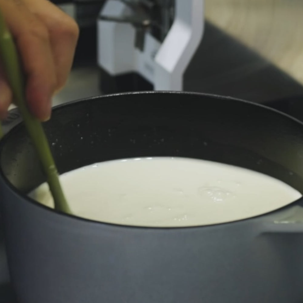 stirring a creamy mixture in a pot during avocado ice cream preparaion