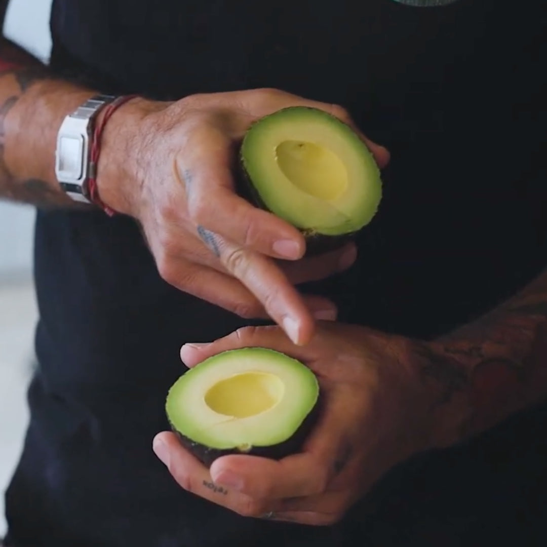 displaying a halved avocado, showcasing its ripe interior
