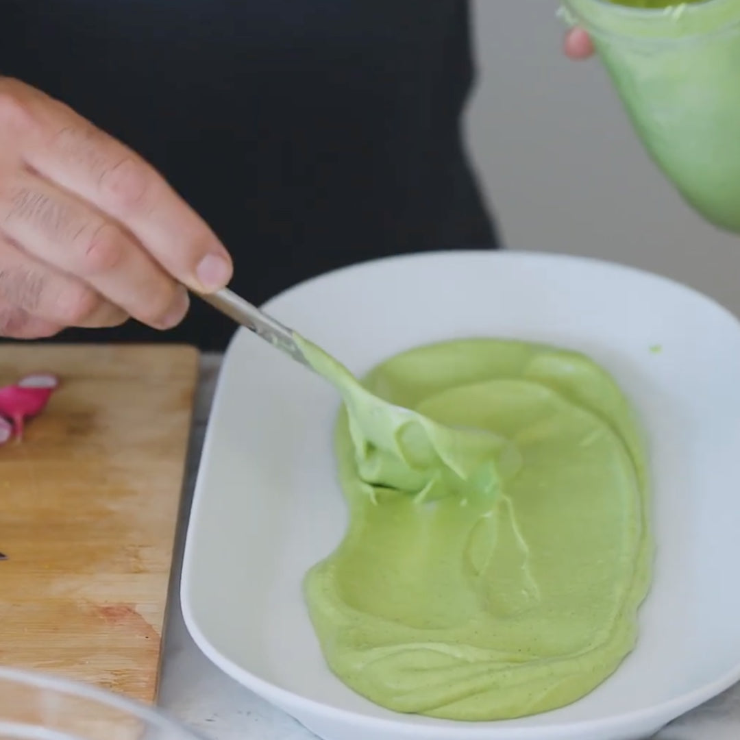 Scooping the avocado ice cream mixture into a bowl for serving