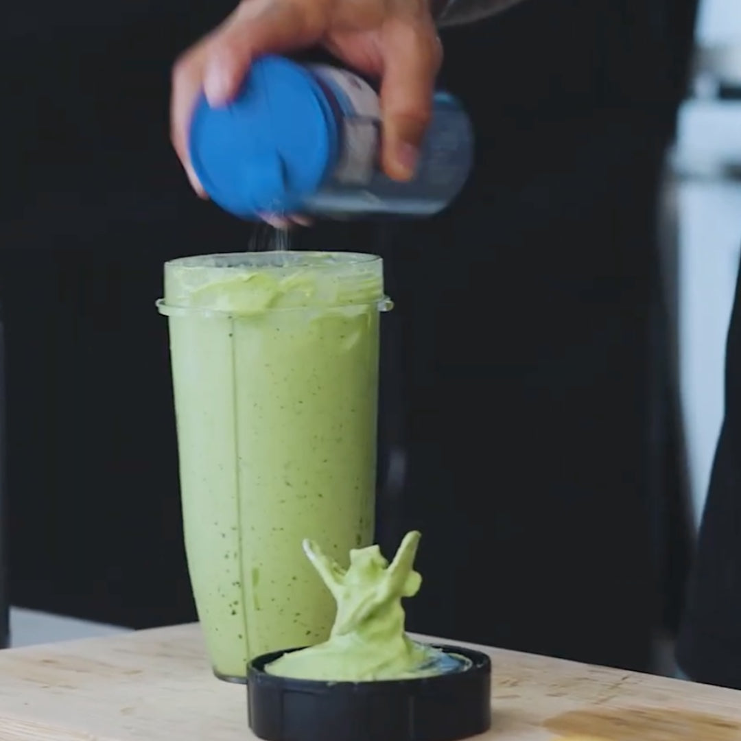 adding seasoning to a blended avocado mixture for ice cream