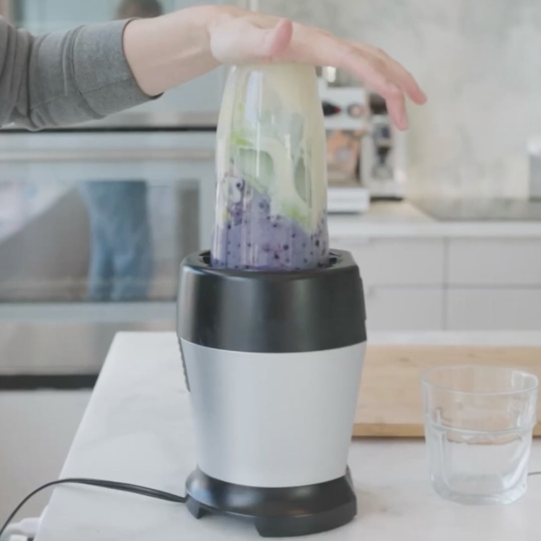 blending ingredients in a blender, with visible blueberries and a creamy mixture
