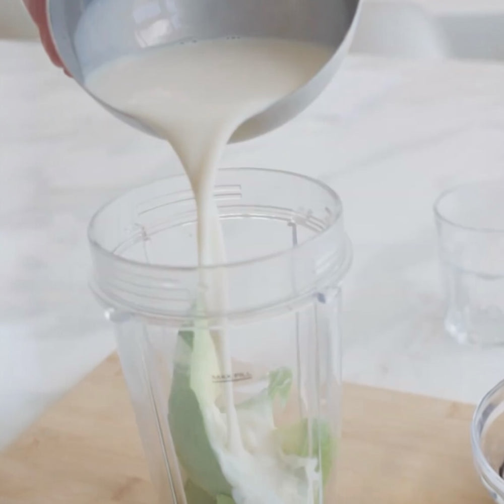 pouring a creamy liquid into a blender jar