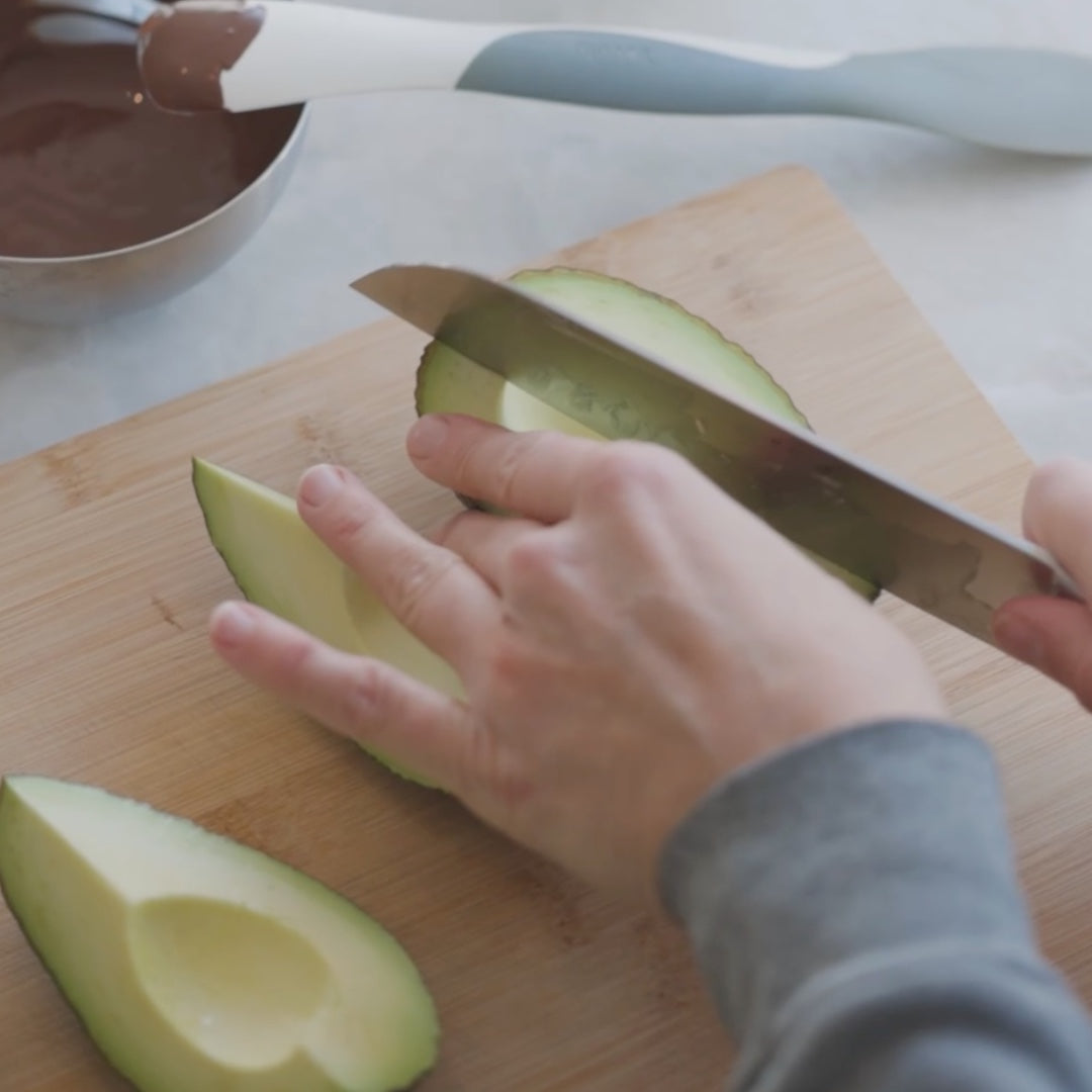 slicing an avocado on a cutting board