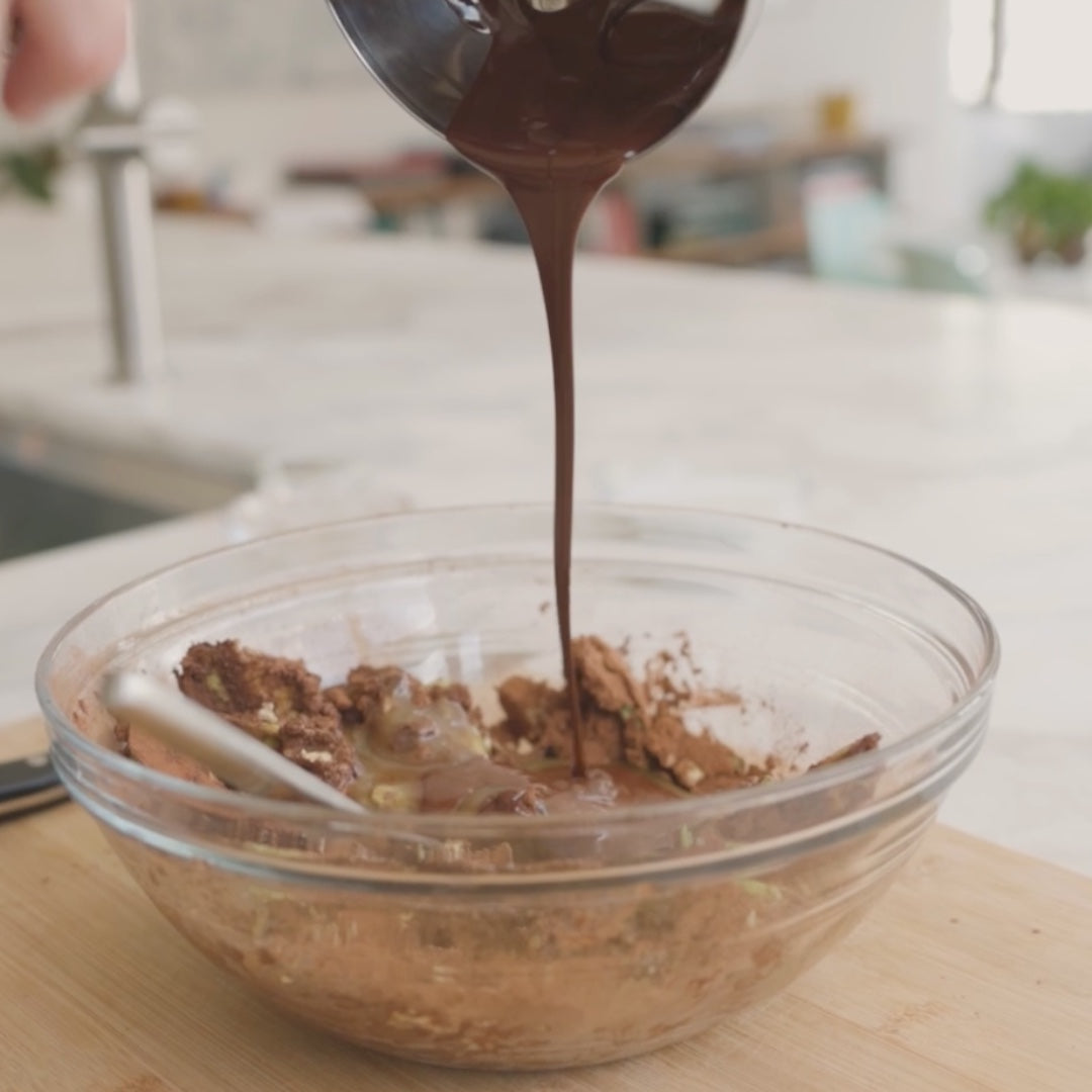 pourring melted chocolate into a bowl of cocoa and avocado