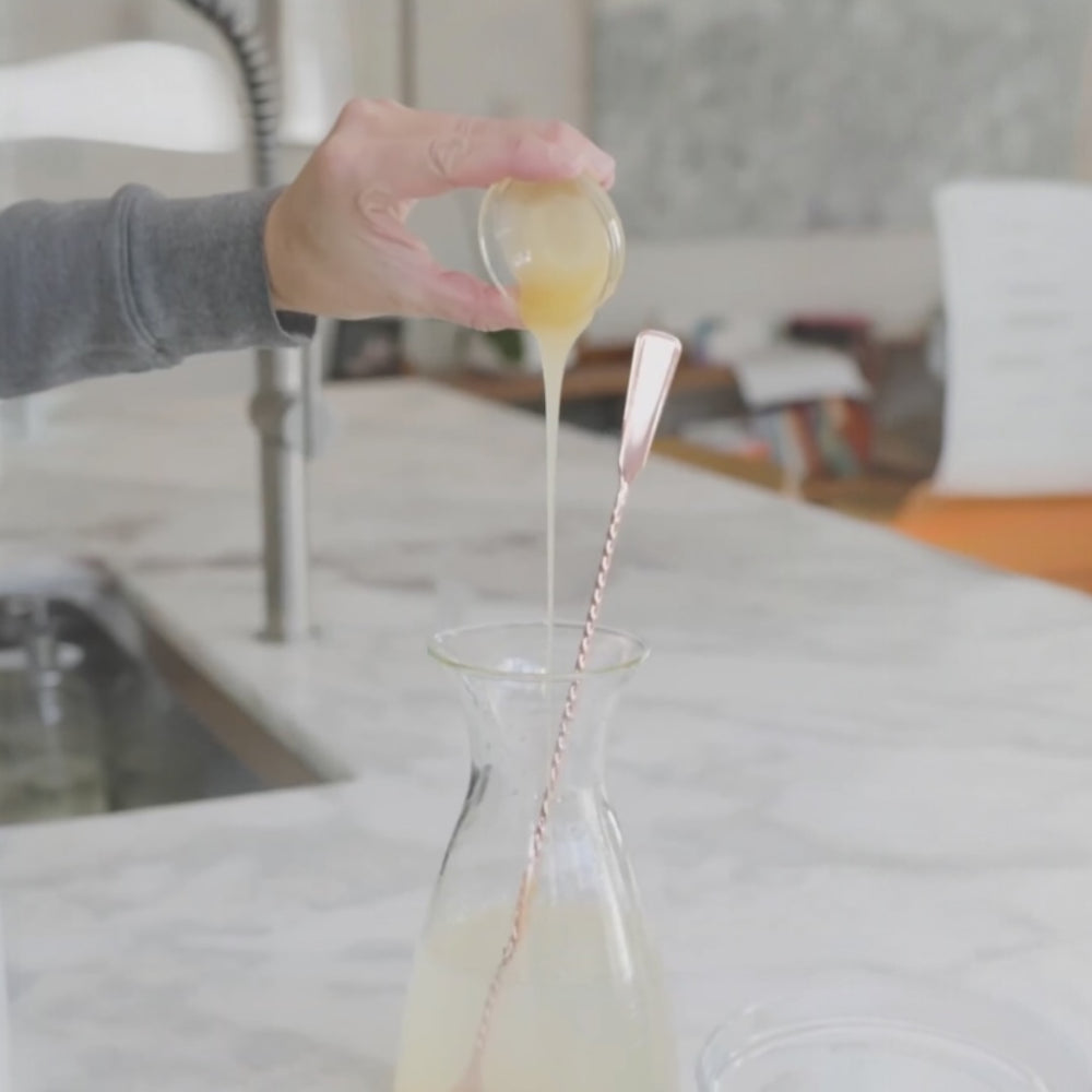 pouring juice into a glass with a spiral stirrer