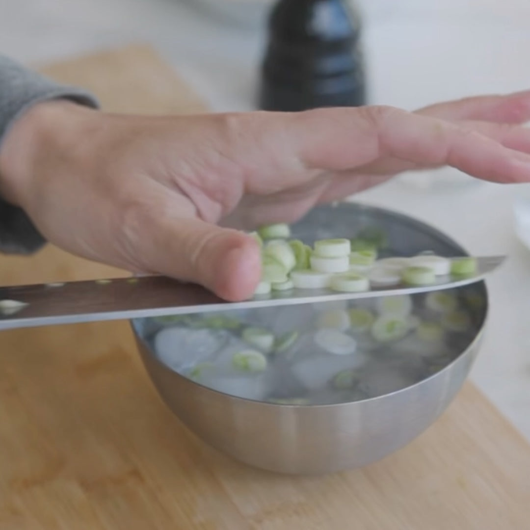 chopping cuumbers into a bowl