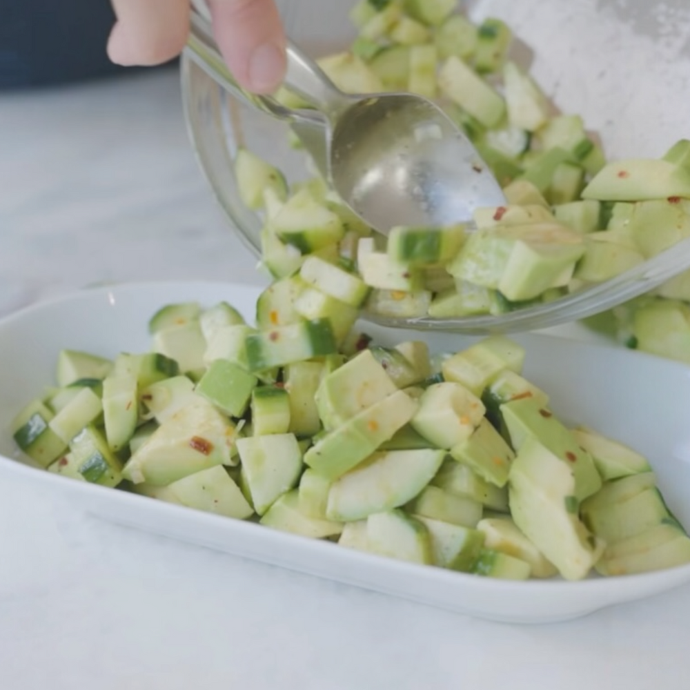 diced avocado pieces being transfered into a bowl using a spoon