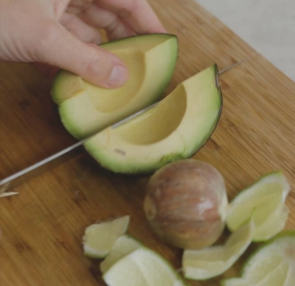 cutting an avocado on a cutting board