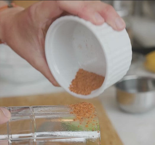 pouring chili powder or spice from a small dish